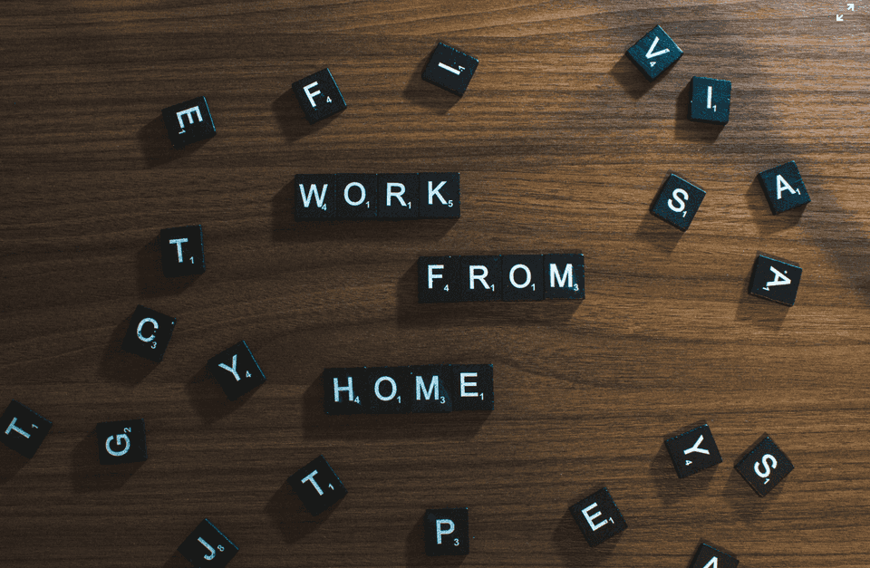 Scrabble letters spelled out 'work from home' surrounded by other random letters